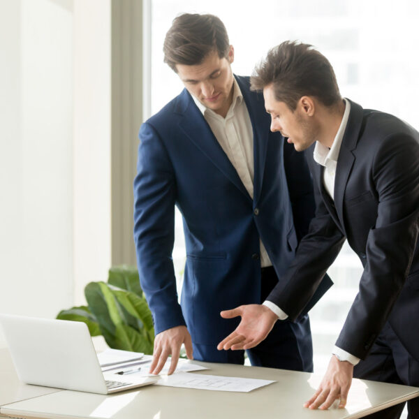 Businessman conducting presentation with business documents to convince investor to finance project. Realtor explaining benefits of estate object when showing drawings or construction plan to client